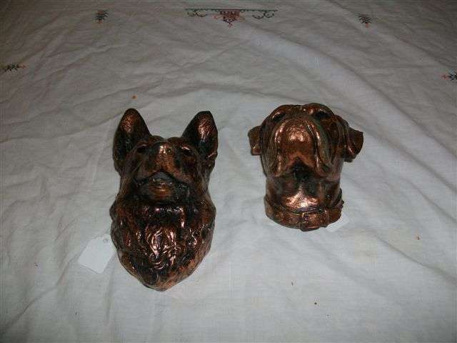 two copper wall haning busts of dogs